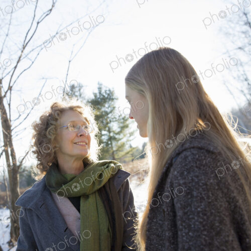 A woman and her adult daughter outdoors in winter snow. A woman and her adult daughter outdoors in winter snow.