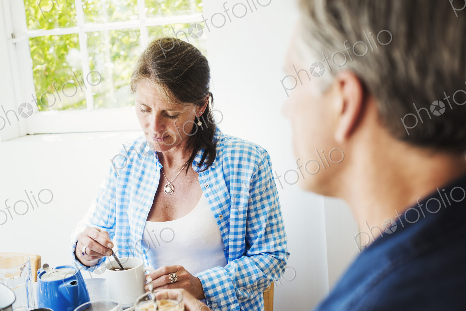 A woman and making talking over a cup of tea.