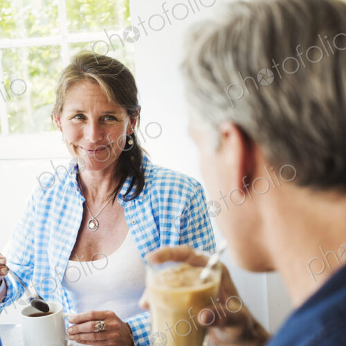 A woman and making talking over a cup of tea. A woman and making talking over a cup of tea.