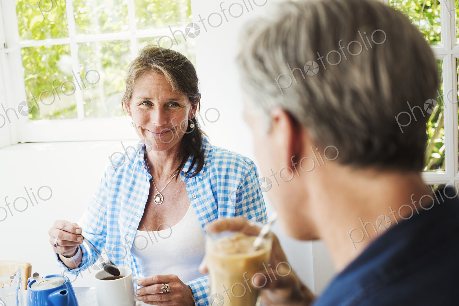 A woman and making talking over a cup of tea.