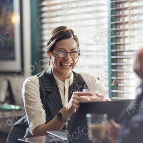 A woman and man in an office at their desks, working over lunch.