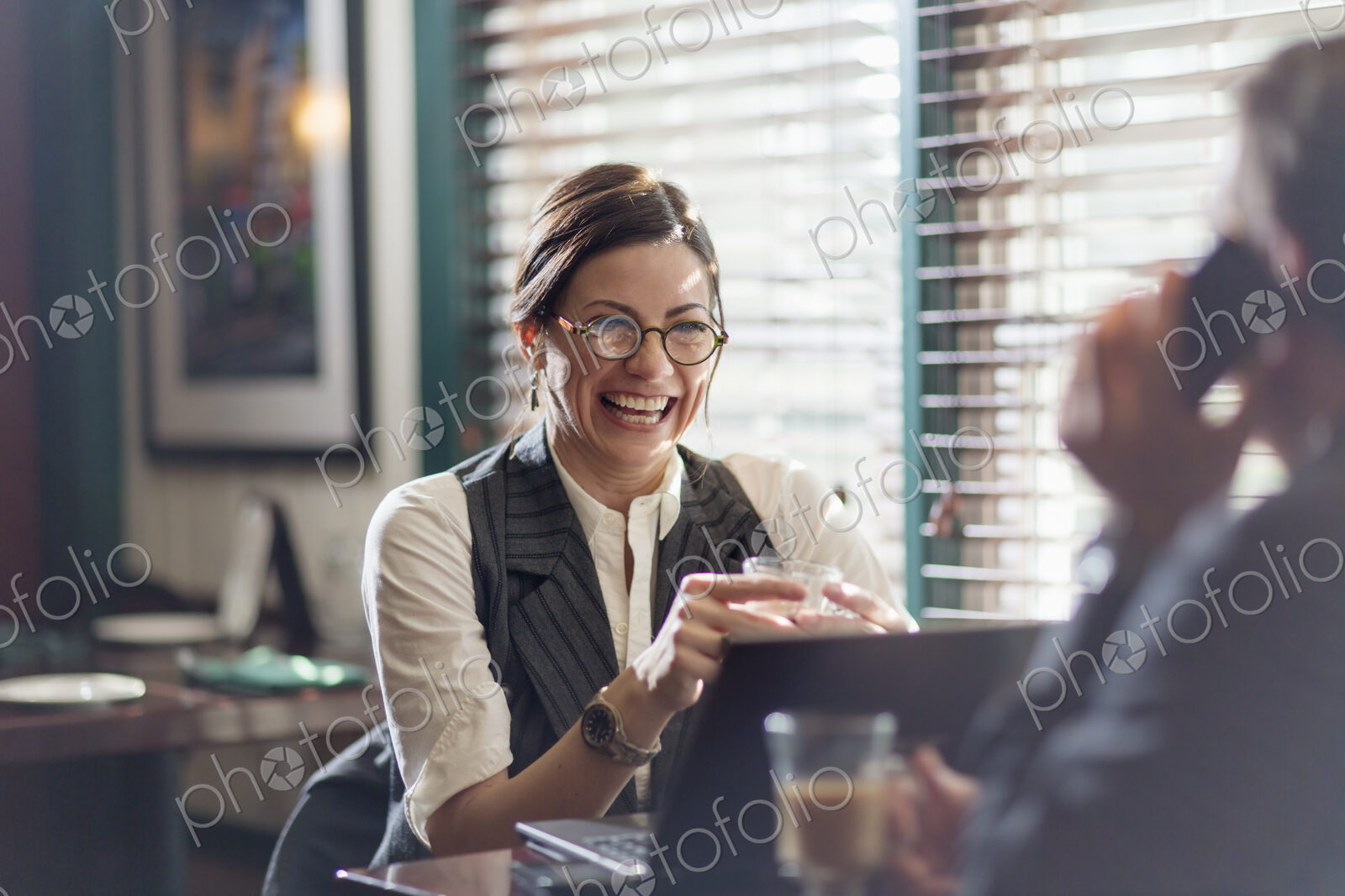 A woman and man in an office at their desks, working over lunch.