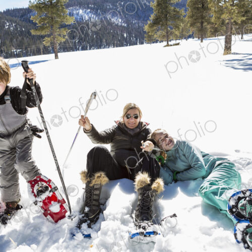 A woman and two children in snow shoes in thick snow