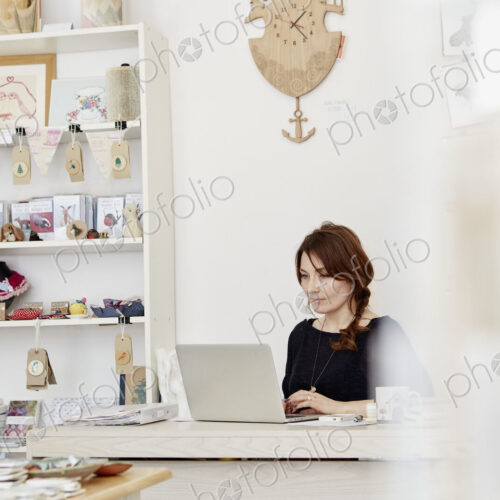 A woman at a desk in a gift shop, doing paperwork