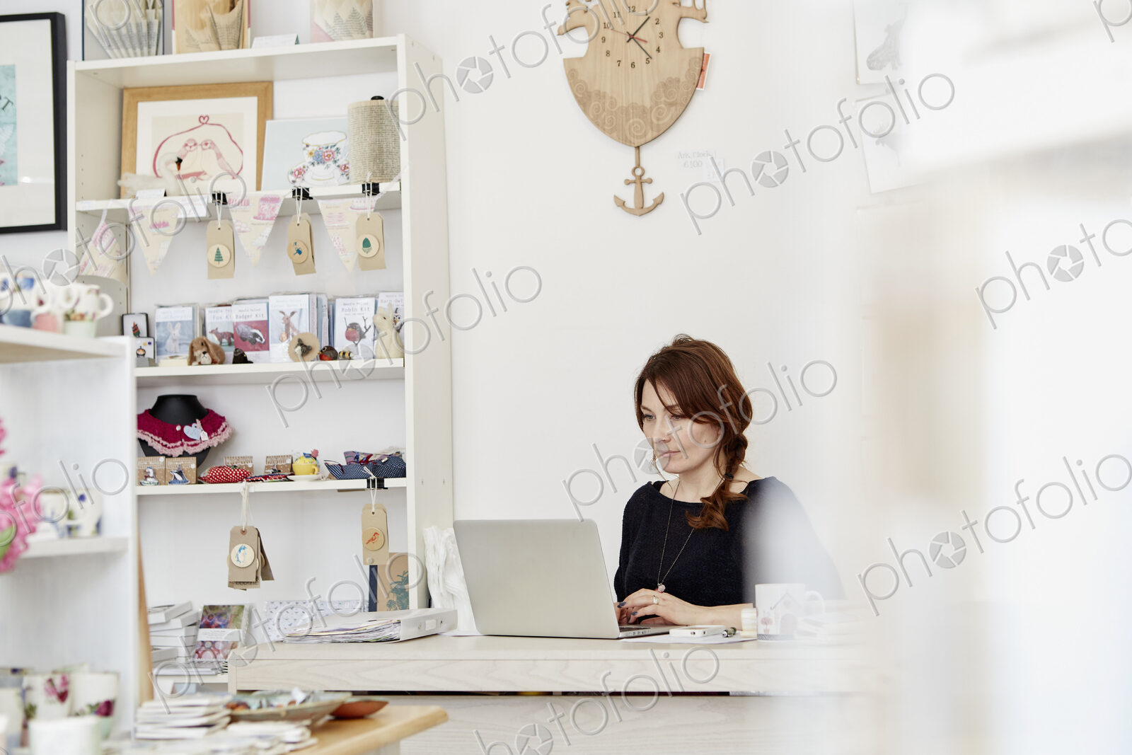 A woman at a desk in a gift shop, doing paperwork