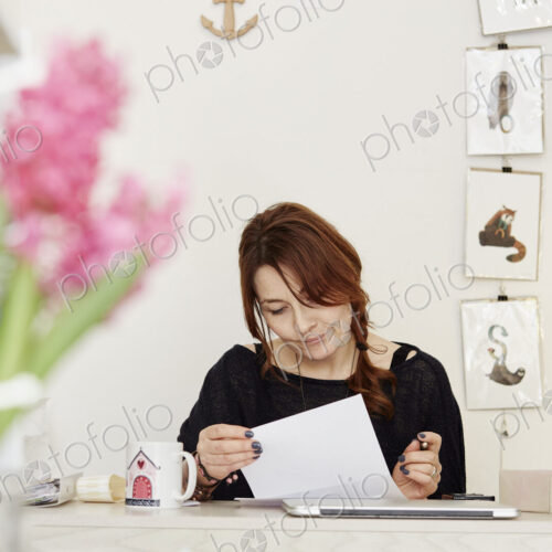 A woman at a desk in a gift shop, doing paperwork