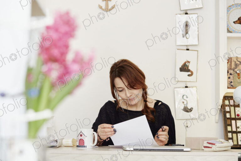 A woman at a desk in a gift shop, doing paperwork