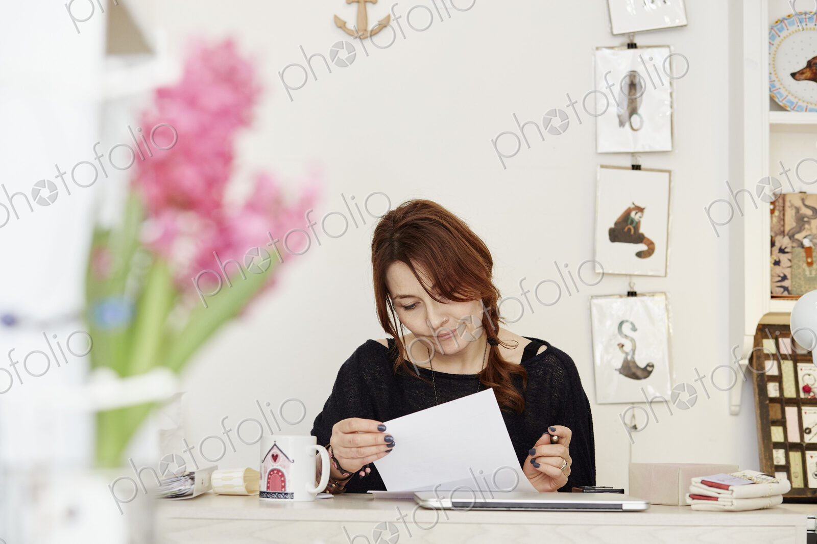 A woman at a desk in a gift shop, doing paperwork
