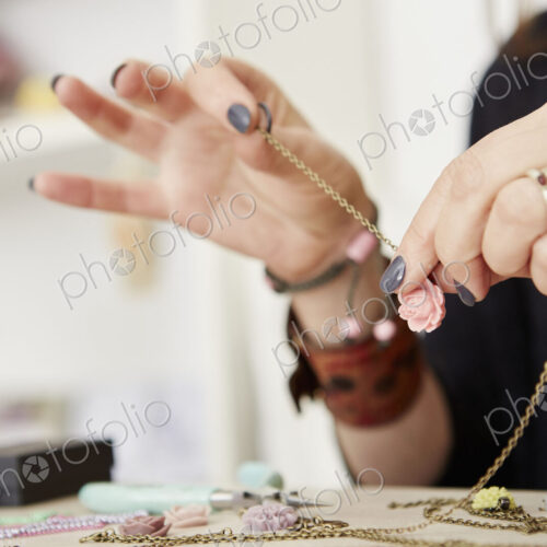 A woman at a workbench making jewellery.