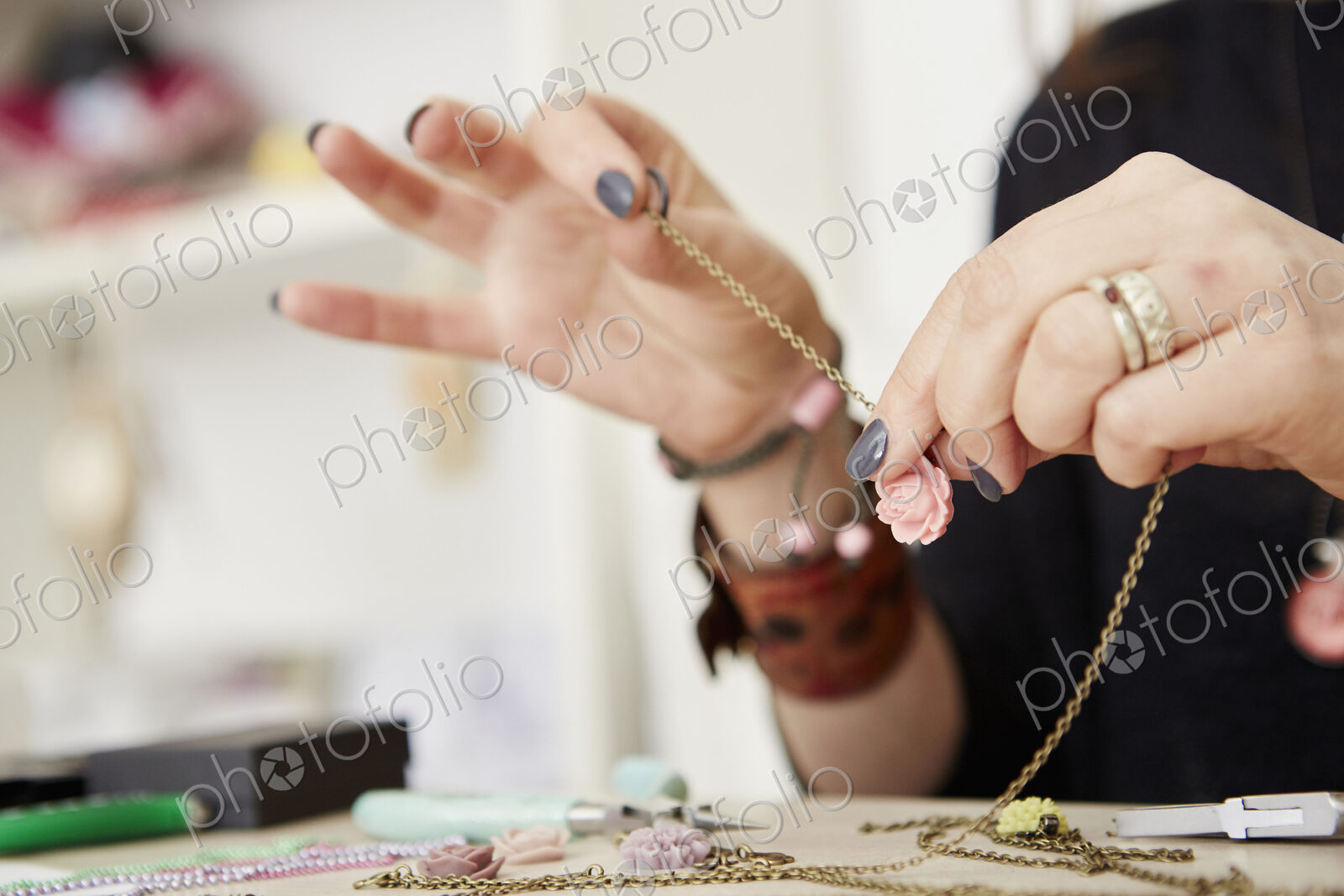 A woman at a workbench making jewellery.