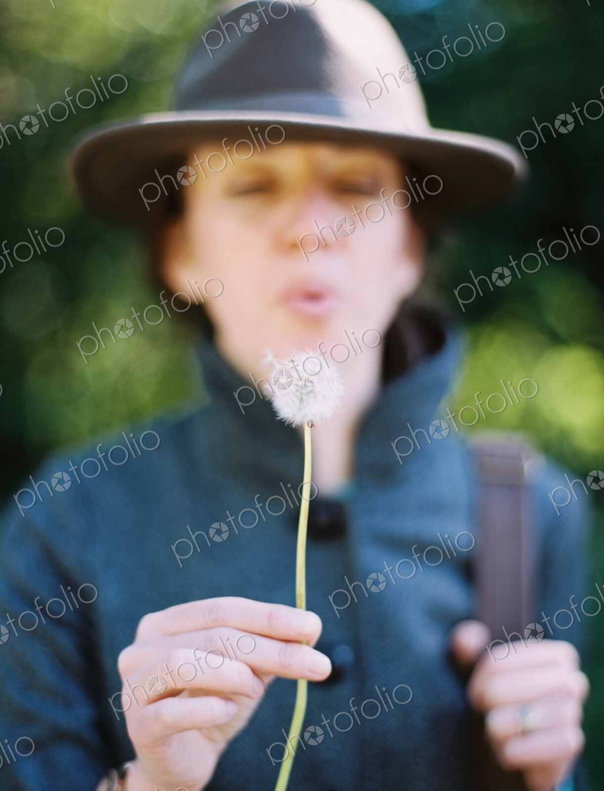 A woman blowing a dandelion clock seedhead. A traditional game.