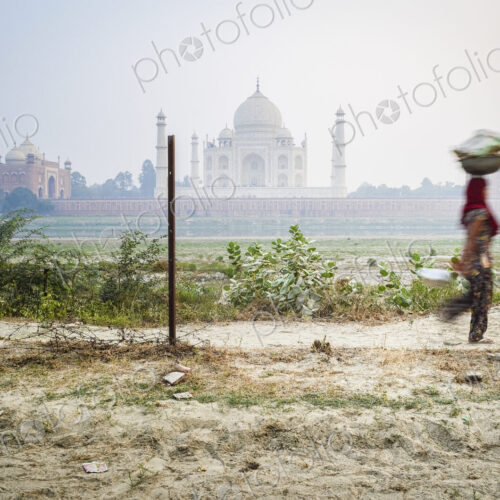 A woman carrying a load on her head, Taj Mahal in background