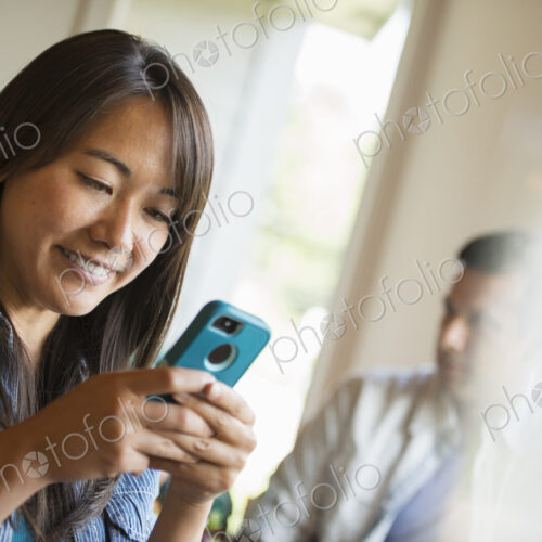 A woman checking her smart phone, in a cafe.