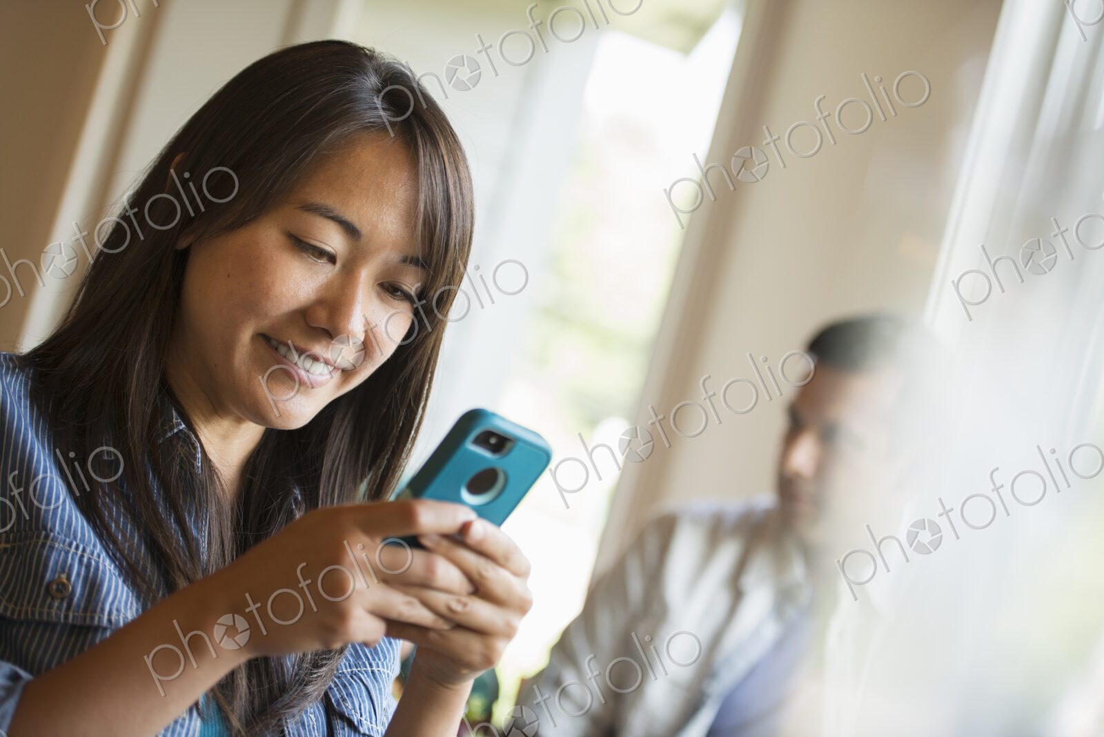 A woman checking her smart phone, in a cafe.