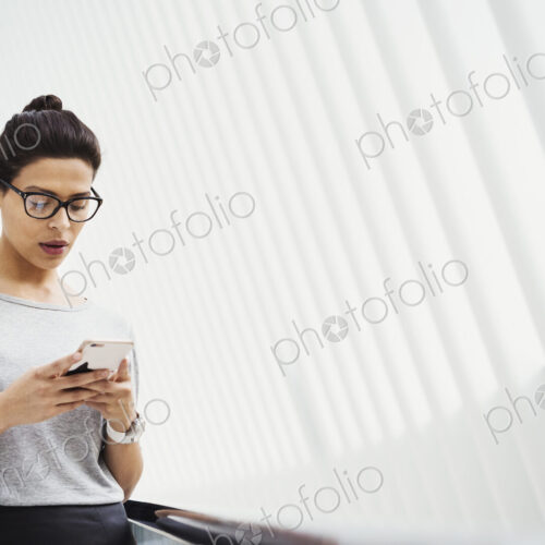 A woman checking social media on her phone, in a light airy space. A woman checking social media on her phone, in a light airy space.