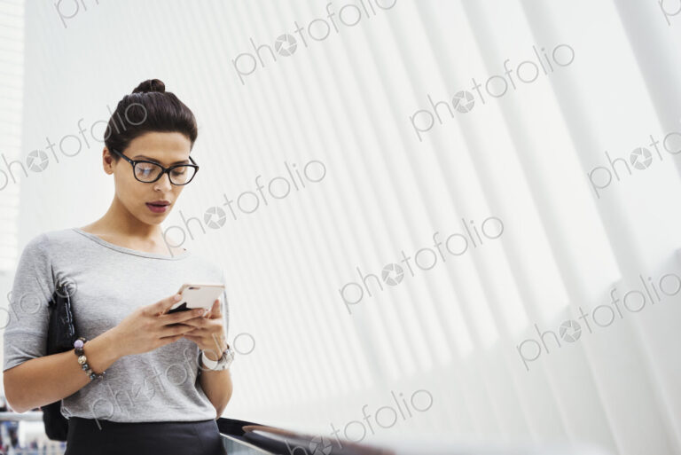 A woman checking social media on her phone, in a light airy space.