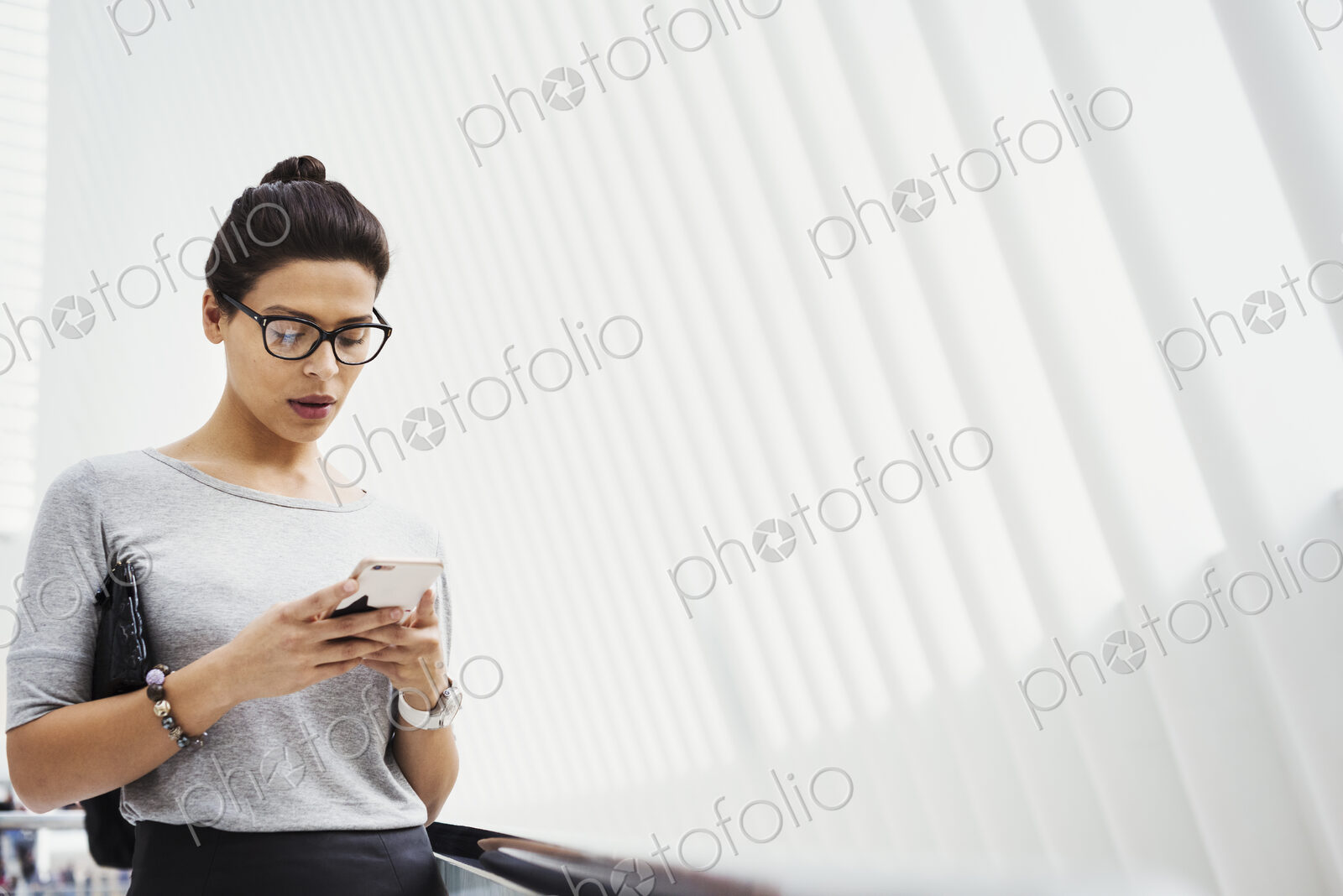 A woman checking social media on her phone, in a light airy space.