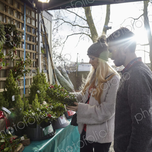 A woman client and a member of staff showing her traditional Christmas wreaths. A woman client and a member of staff showing her traditional Christmas wreaths.