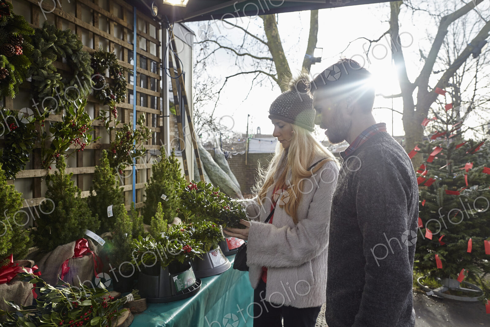 A woman client and a member of staff showing her traditional Christmas wreaths.