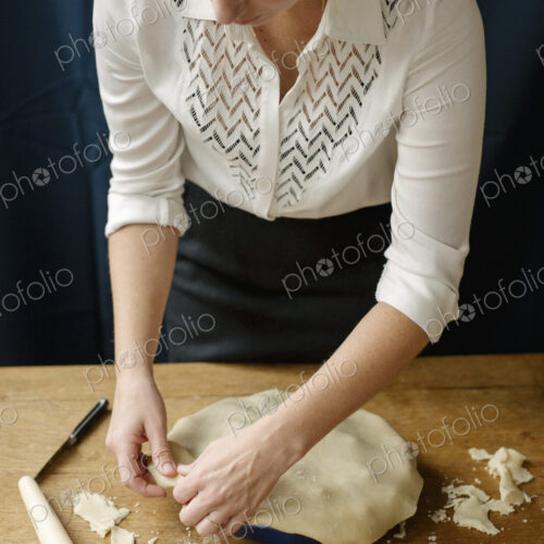 A woman crimping the pastry edge of a home made pie. A woman crimping the pastry edge of a home made pie.