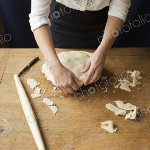 A woman crimping the pastry edge of a home made pie. A woman crimping the pastry edge of a home made pie.