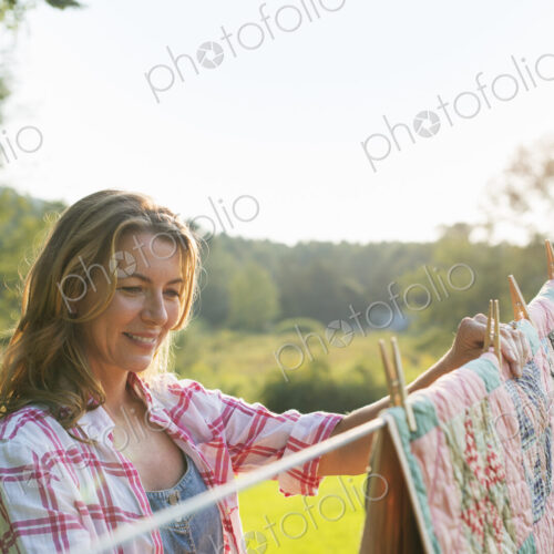 A woman hanging laundry on the washing line, in the fresh air.