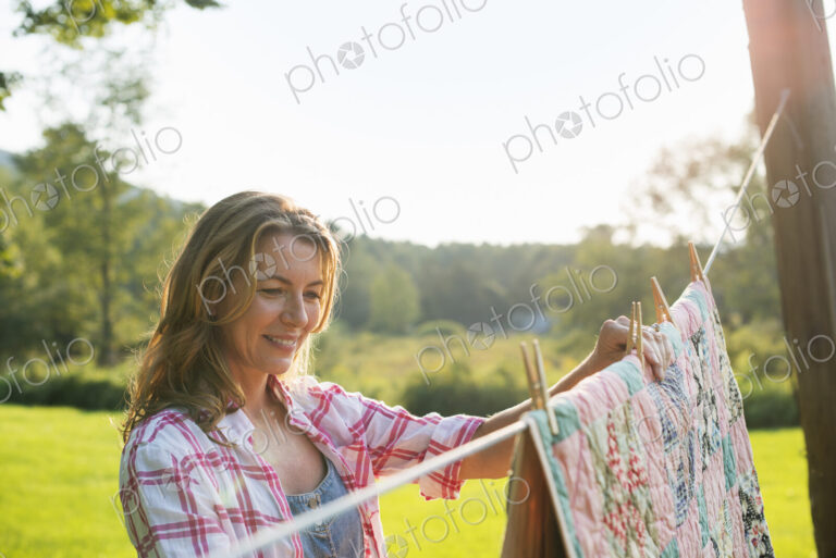 A woman hanging laundry on the washing line, in the fresh air.