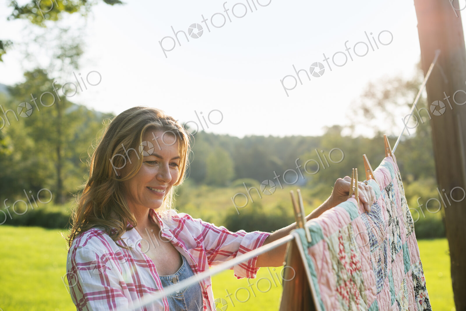 A woman hanging laundry on the washing line, in the fresh air.