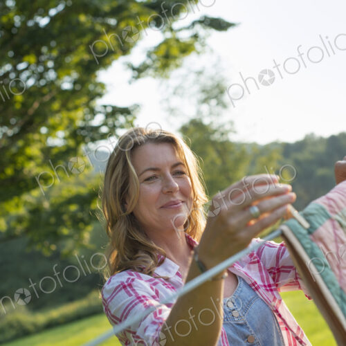 A woman hanging laundry on the washing line, in the fresh air.
