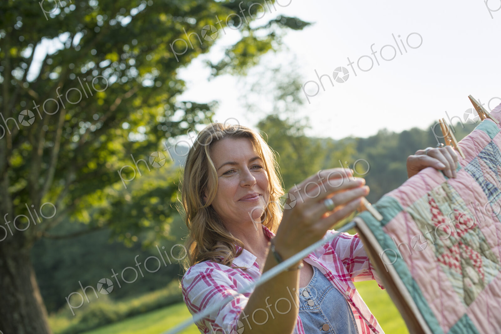 A woman hanging laundry on the washing line, in the fresh air.