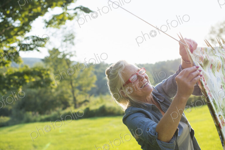 A woman hanging laundry on the washing line, in the fresh air.