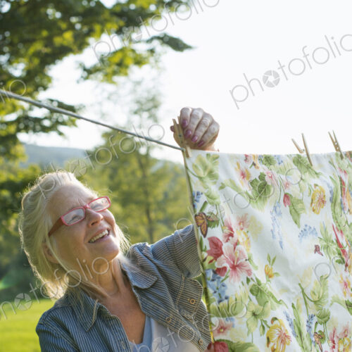 A woman hanging laundry on the washing line, in the fresh air.