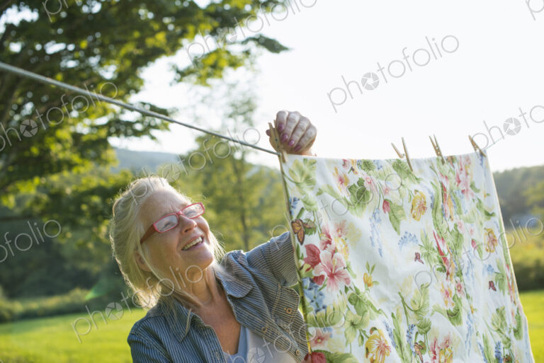 A woman hanging laundry on the washing line, in the fresh air.