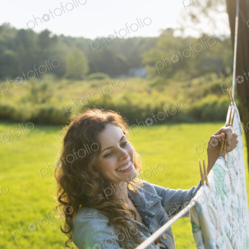 A woman hanging laundry on the washing line, in the fresh air.