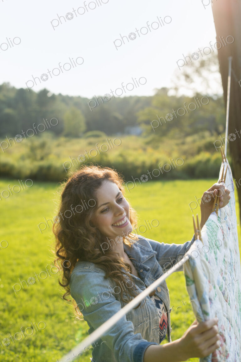 A woman hanging laundry on the washing line, in the fresh air.