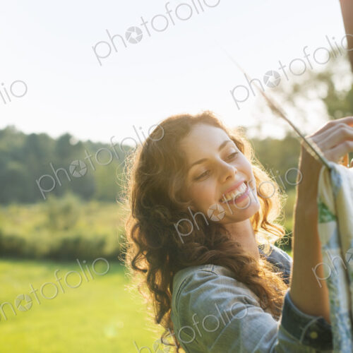 A woman hanging laundry on the washing line, in the fresh air.