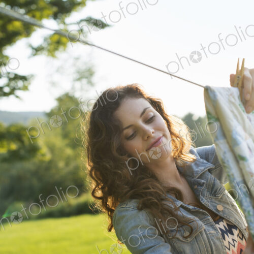 A woman hanging laundry on the washing line, in the fresh air.