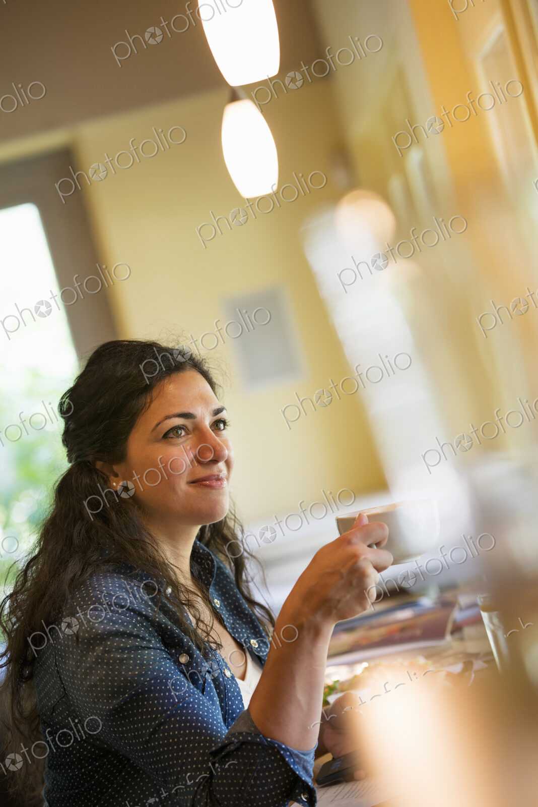 A woman having a cup of coffee.