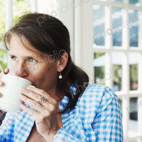 A woman having a cup of coffee. A woman having a cup of coffee.