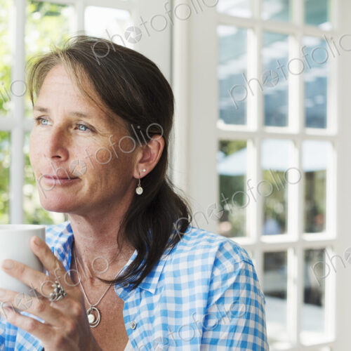 A woman having a cup of coffee. A woman having a cup of coffee.