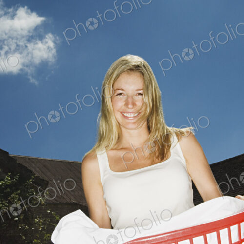 A woman holding a basket of washing. A woman holding a basket of washing.