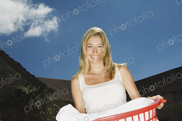 A woman holding a basket of washing.