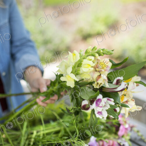 A woman holding a bunch of summer garden flowers.