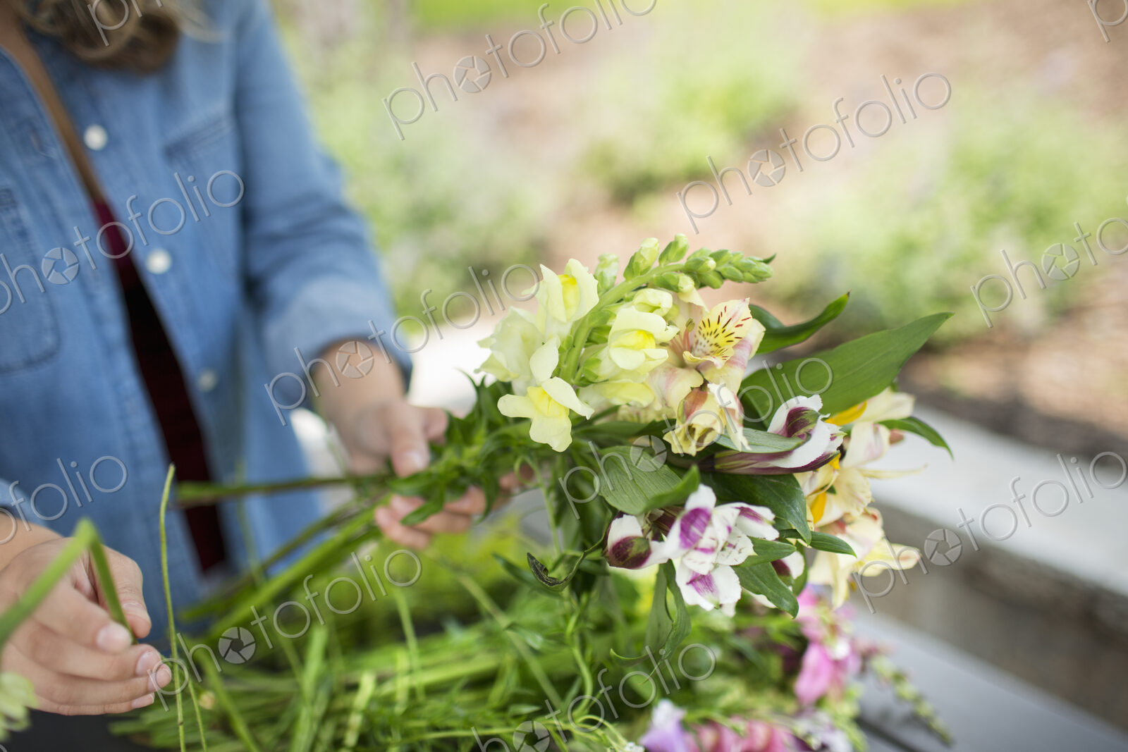 A woman holding a bunch of summer garden flowers.