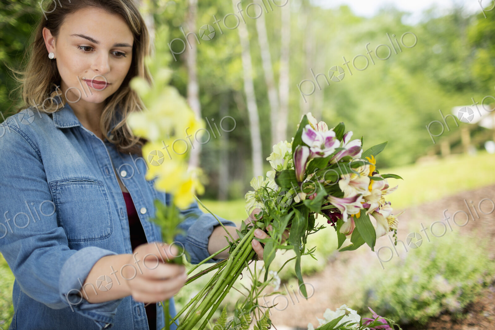 A woman holding a bunch of summer garden flowers.