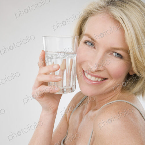 A woman holding a glass of water. A woman holding a glass of water.