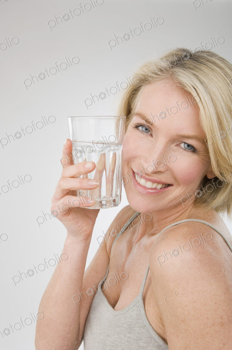 A woman holding a glass of water.