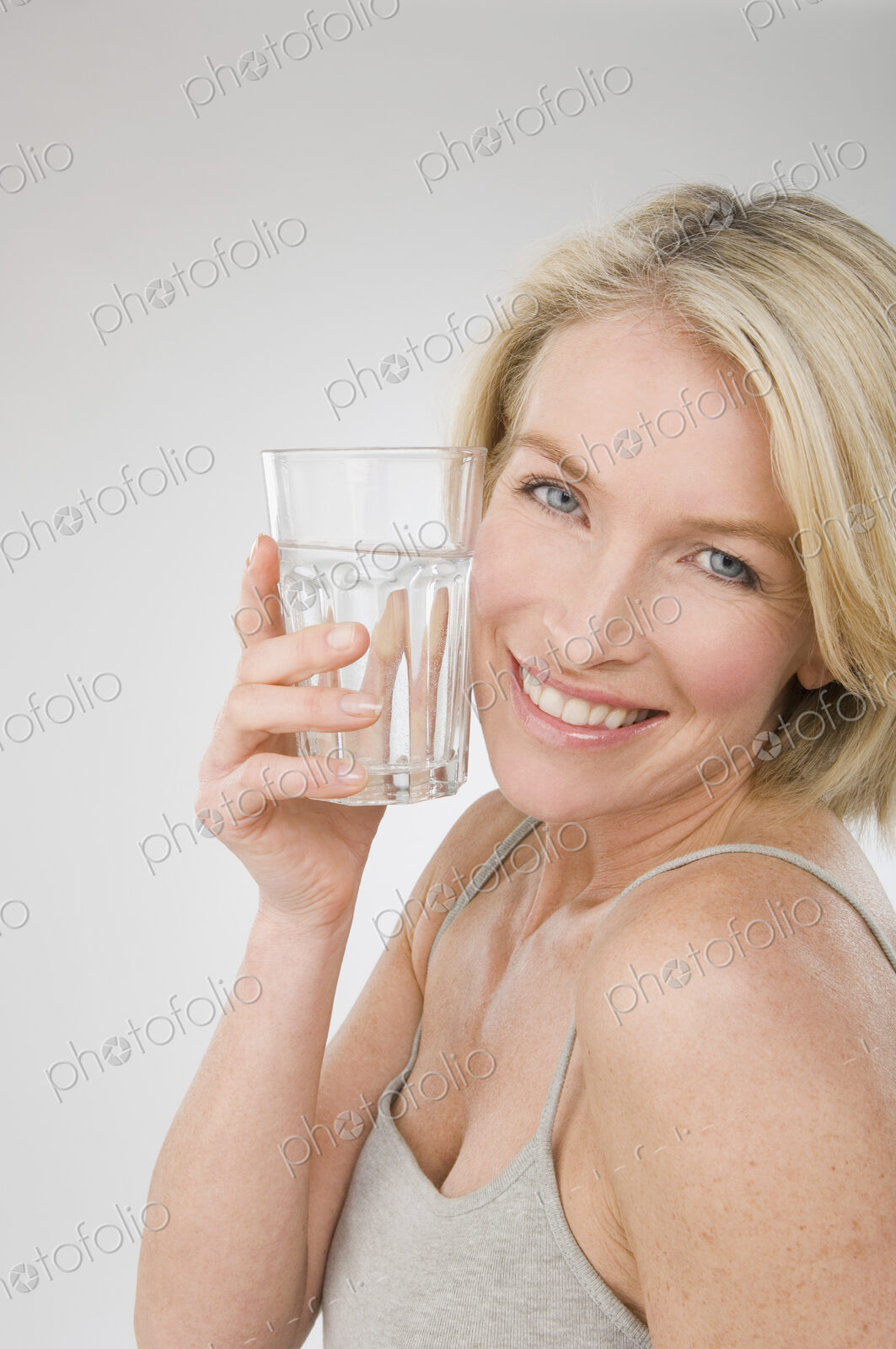 A woman holding a glass of water.