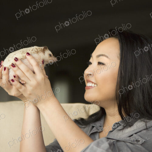 A woman holding a hedgehog in her hands. A woman holding a hedgehog in her hands.