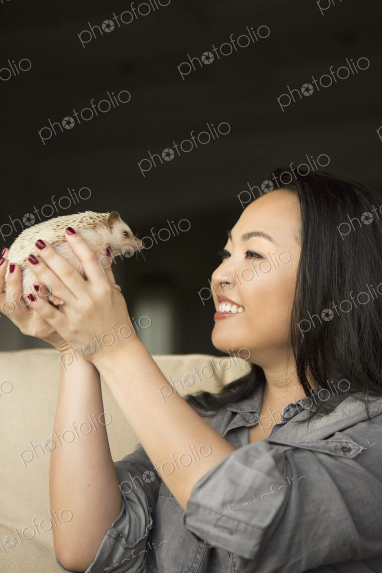A woman holding a hedgehog in her hands.